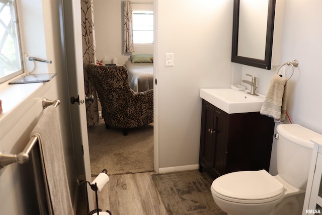 bathroom featuring wood-type flooring, vanity, and toilet