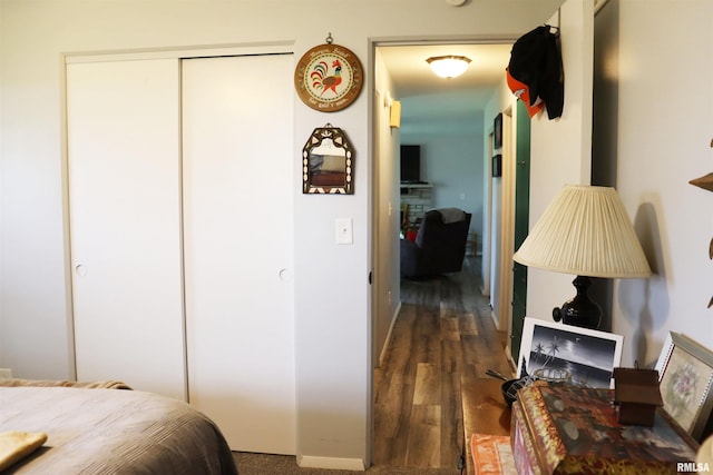 bedroom with dark hardwood / wood-style flooring and a closet