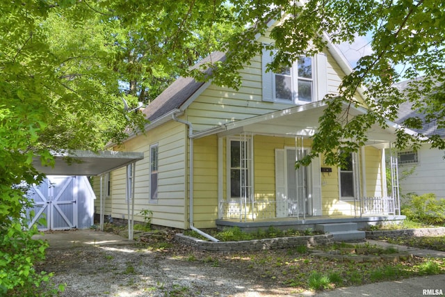 view of front facade featuring a storage shed and covered porch