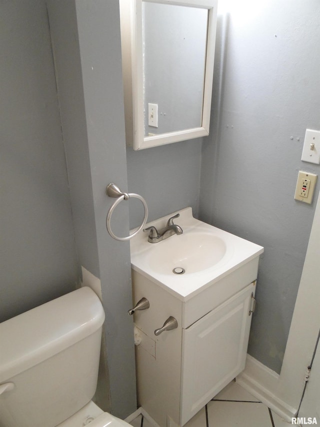 bathroom featuring vanity with extensive cabinet space, tile flooring, and toilet