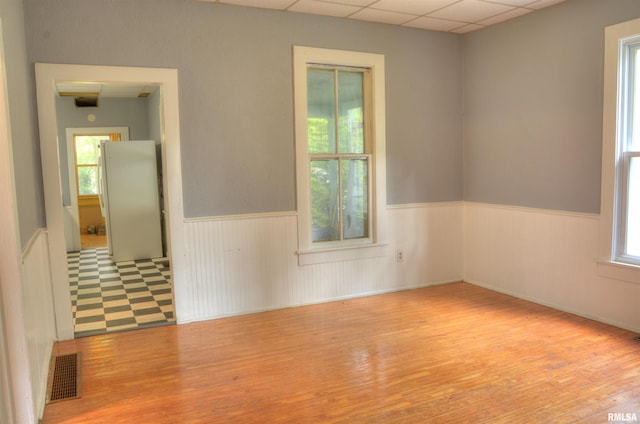 empty room featuring wood-type flooring and a drop ceiling