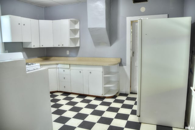 kitchen with open shelves, light floors, light countertops, and freestanding refrigerator