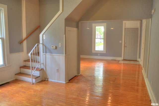 unfurnished living room featuring a high ceiling and light hardwood / wood-style floors