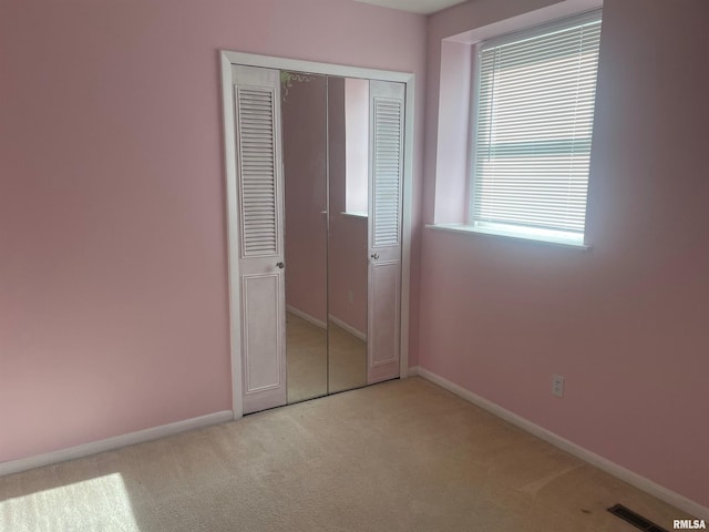 unfurnished bedroom featuring a closet, carpet floors, and multiple windows