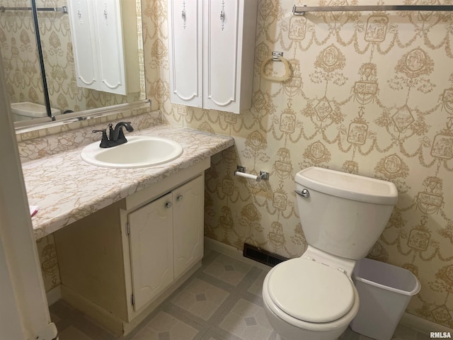 bathroom featuring tile flooring, vanity, and toilet