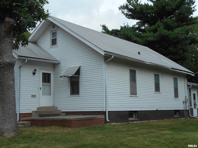 rear view of house featuring a lawn