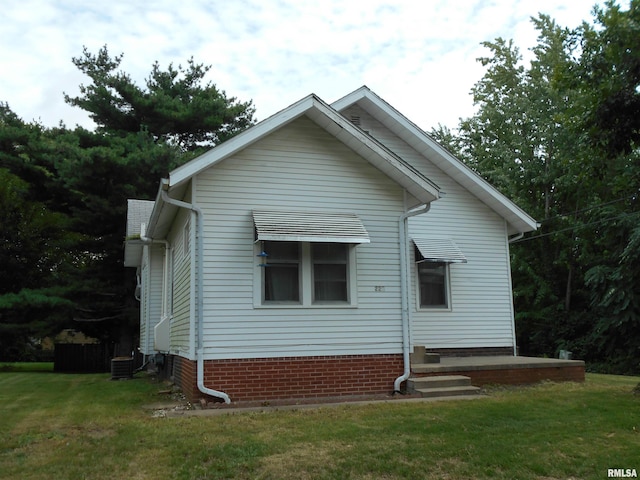 rear view of property with a lawn and cooling unit