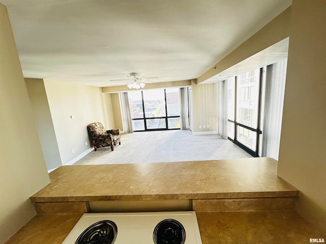 interior space featuring light colored carpet and ceiling fan