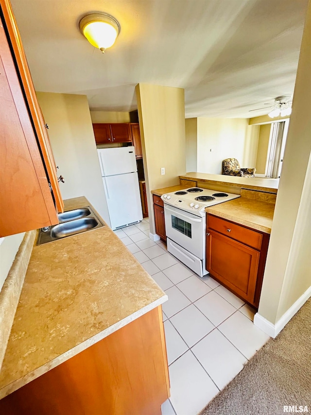 kitchen with kitchen peninsula, ceiling fan, light tile patterned flooring, and white appliances