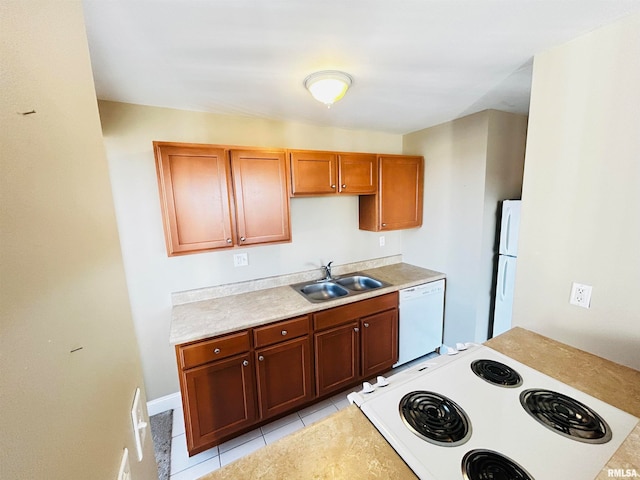 kitchen featuring sink, light tile patterned flooring, and white appliances