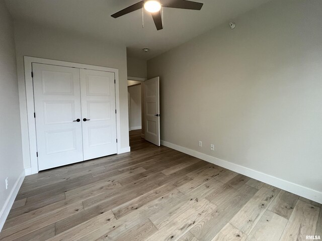 unfurnished bedroom with ceiling fan, light hardwood / wood-style flooring, and a closet