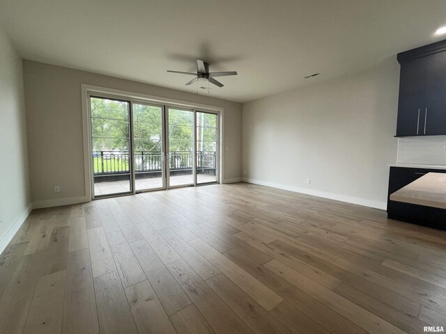 unfurnished living room featuring ceiling fan and wood-type flooring