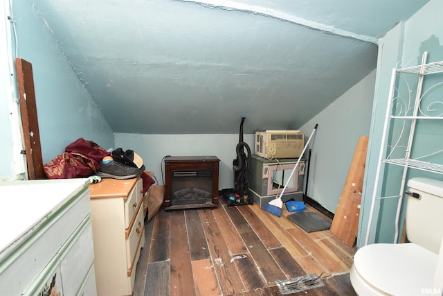 interior space with wood-type flooring, a fireplace, a wall mounted AC, and vaulted ceiling