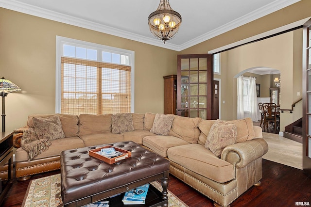 living area with stairs, a chandelier, arched walkways, dark wood finished floors, and ornamental molding