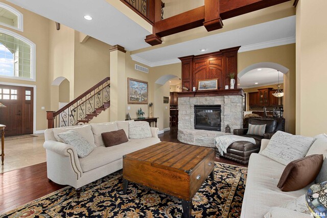 living room with a towering ceiling, visible vents, and arched walkways