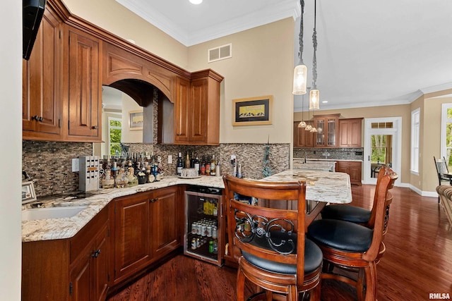 kitchen with dark wood-style flooring, wine cooler, visible vents, and a breakfast bar area