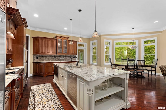 kitchen featuring open shelves, a sink, a center island with sink, decorative backsplash, and glass insert cabinets