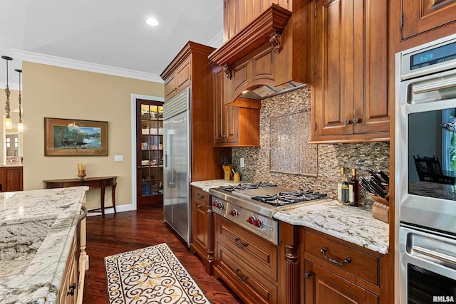 kitchen featuring brown cabinetry, decorative backsplash, appliances with stainless steel finishes, and crown molding
