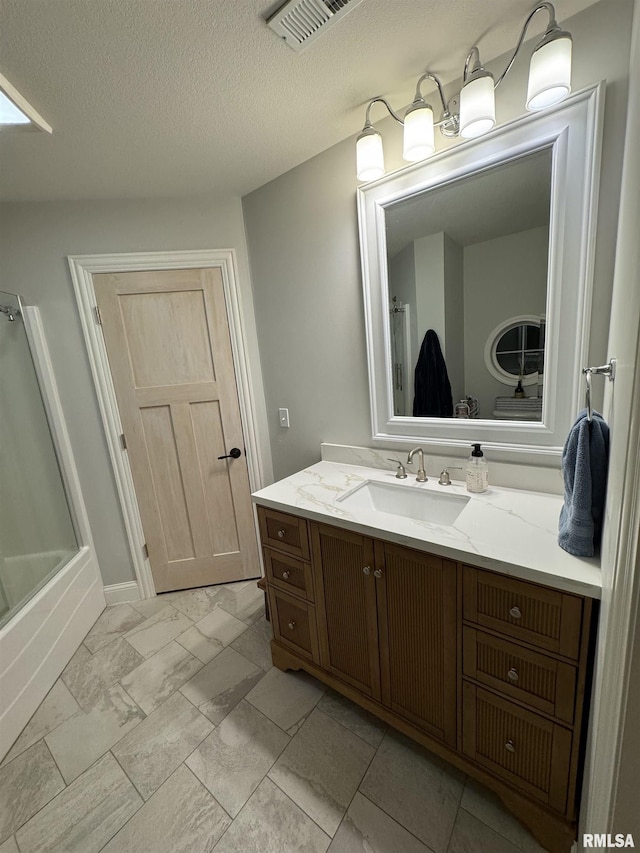 bathroom featuring a textured ceiling, baseboards, visible vents, marble finish floor, and vanity