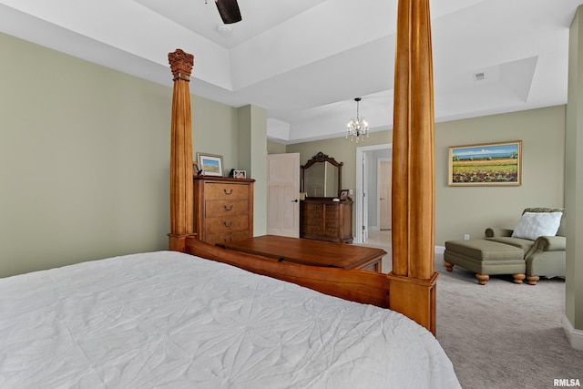 bedroom with a tray ceiling, visible vents, carpet floors, baseboards, and decorative columns