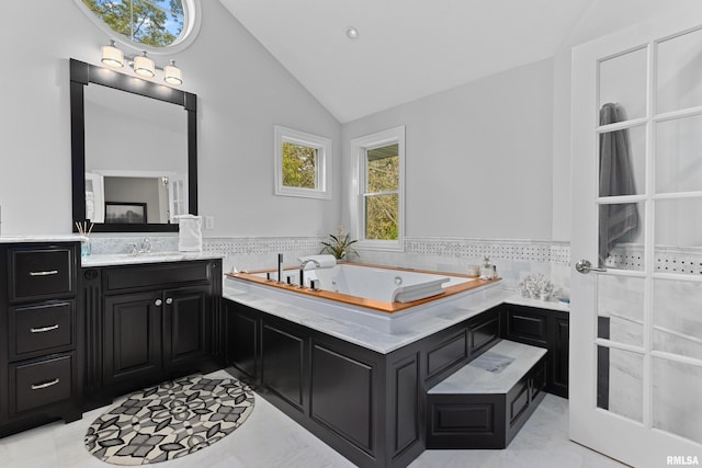 bathroom featuring a bath, vanity, and high vaulted ceiling