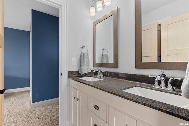 bathroom with baseboards, a sink, and double vanity