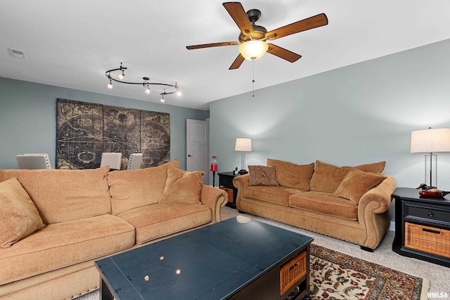 living area with carpet, visible vents, and ceiling fan