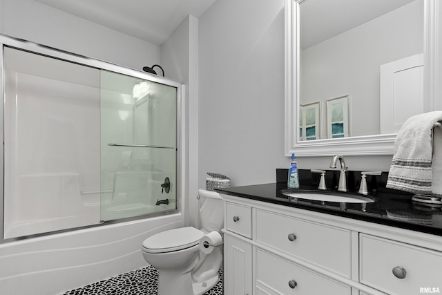 bathroom with vanity, tile patterned flooring, shower / bath combination with glass door, and toilet