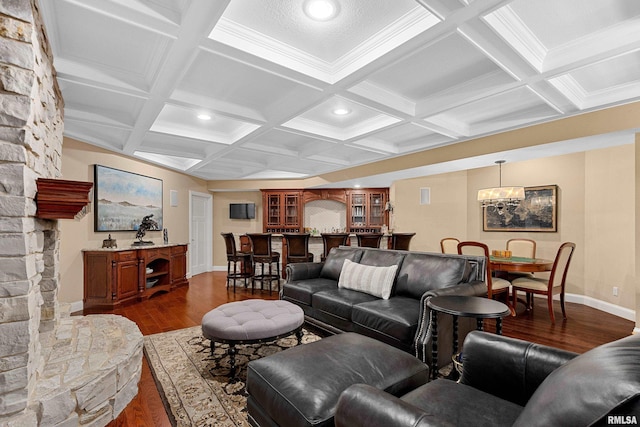 living area with an inviting chandelier, coffered ceiling, dark wood-type flooring, baseboards, and beam ceiling