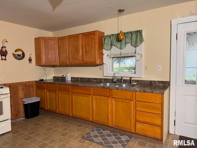 kitchen featuring white range oven, sink, and pendant lighting