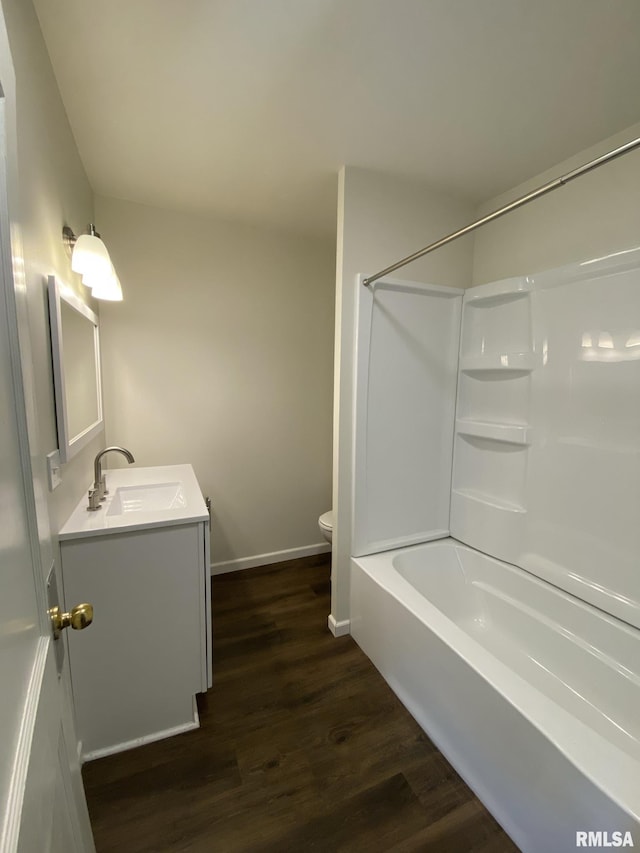 full bathroom with wood-type flooring, toilet,  shower combination, and vanity