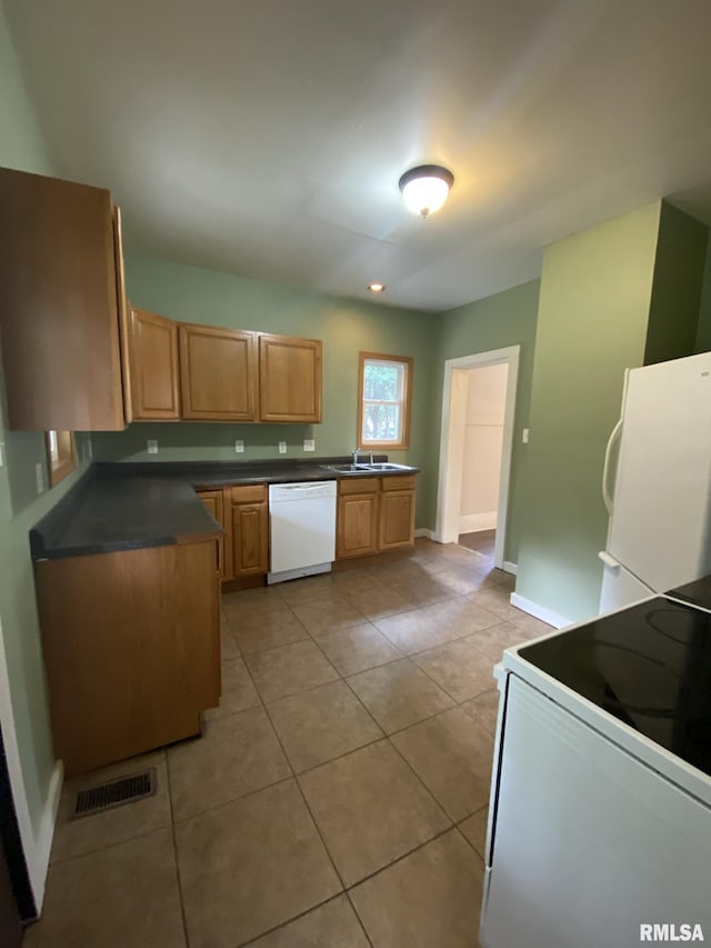 kitchen with light tile patterned flooring, white appliances, and sink