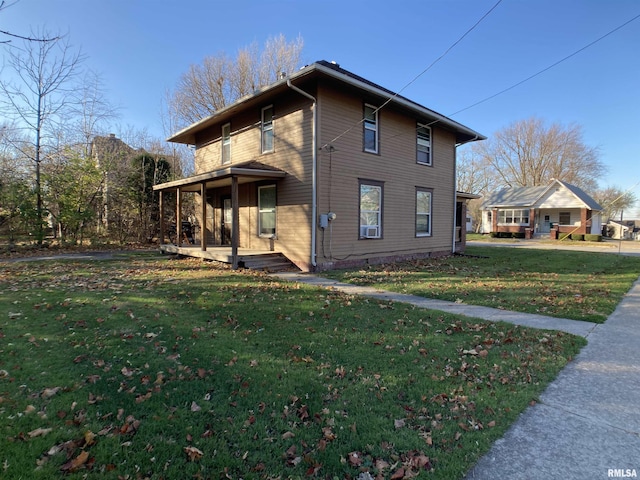 view of side of home featuring a lawn and covered porch