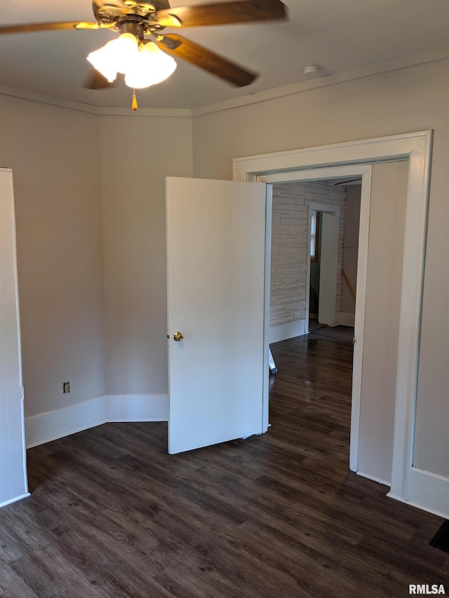 spare room featuring ornamental molding, dark wood-type flooring, and ceiling fan