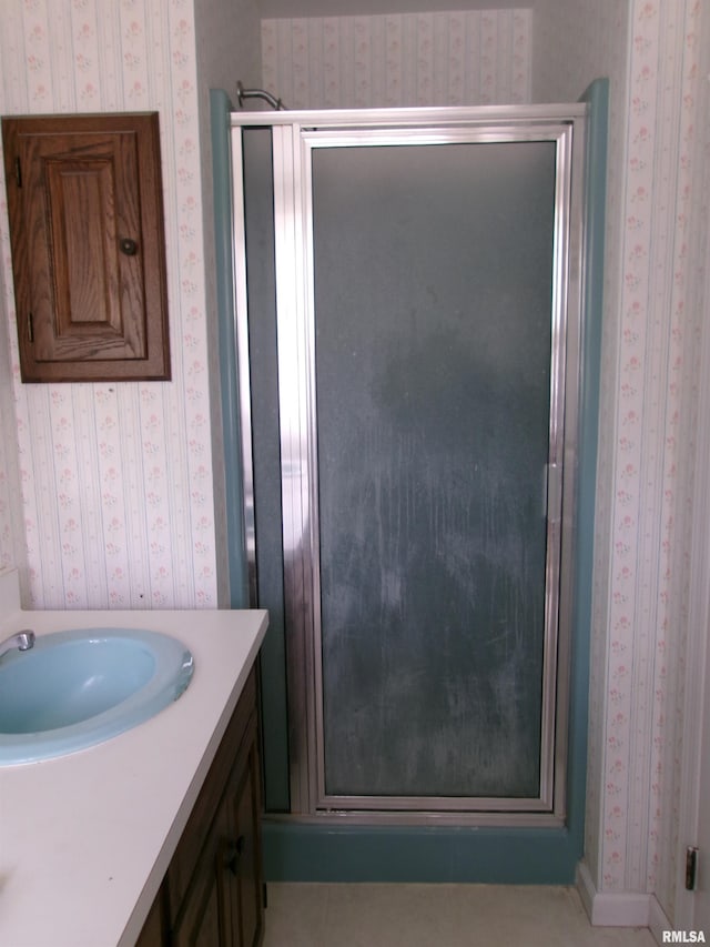 bathroom with a shower with door and vanity