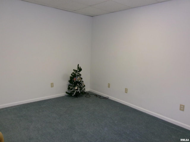 carpeted spare room featuring a drop ceiling