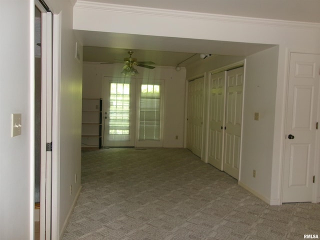 carpeted spare room featuring ceiling fan and crown molding