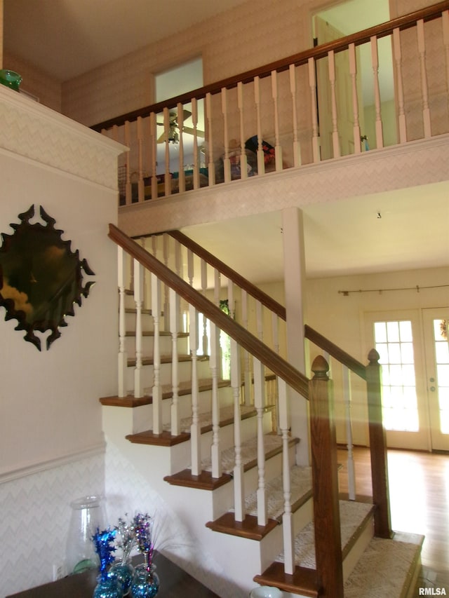 staircase with french doors and a high ceiling