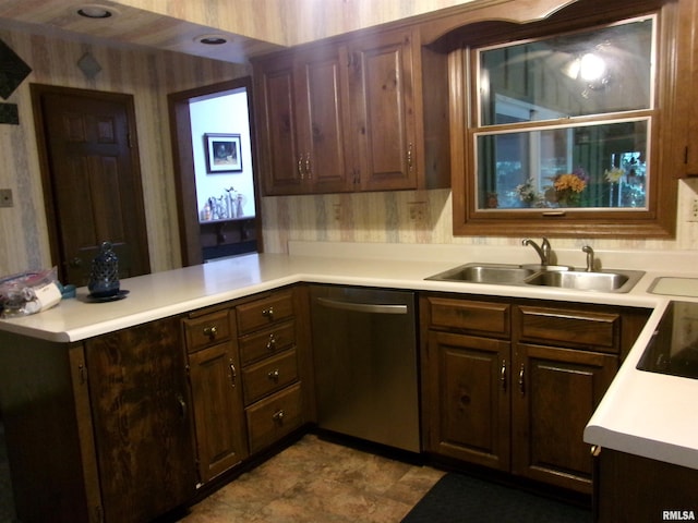 kitchen with kitchen peninsula, dark brown cabinetry, sink, stainless steel dishwasher, and stovetop