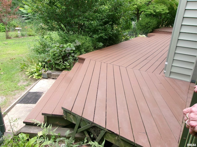 wooden terrace featuring a lawn