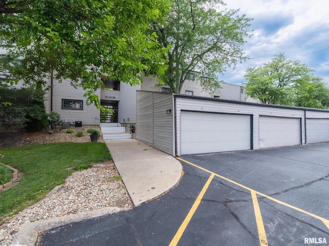 view of front of home featuring a garage and central air condition unit