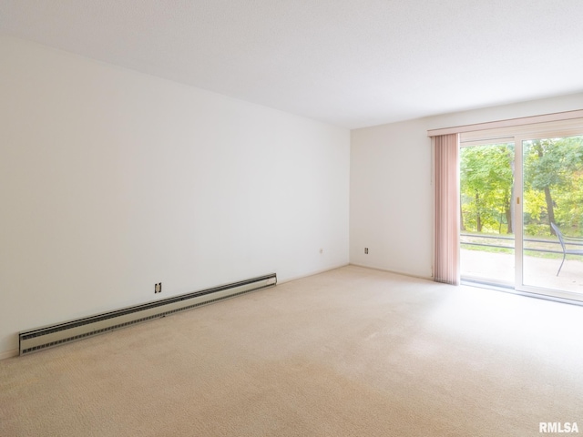 unfurnished room featuring a baseboard heating unit and light colored carpet