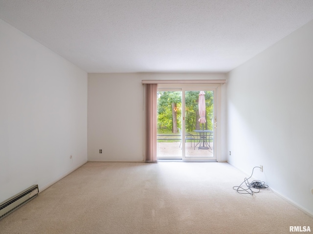 carpeted empty room featuring baseboard heating and a textured ceiling