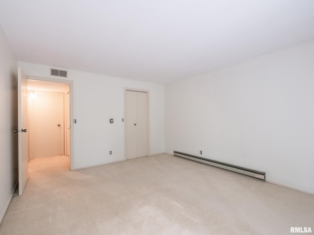 unfurnished room with light colored carpet, a baseboard radiator, and visible vents