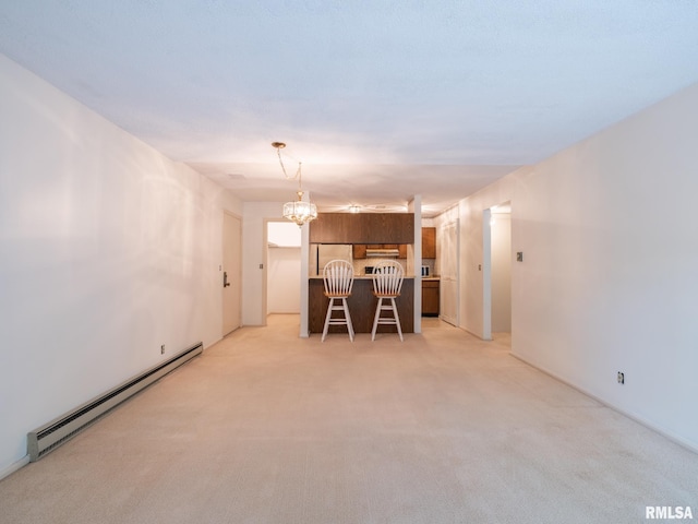 unfurnished dining area featuring a baseboard heating unit, light carpet, and an inviting chandelier