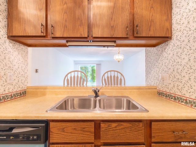 kitchen featuring dishwashing machine, wallpapered walls, light countertops, and a sink