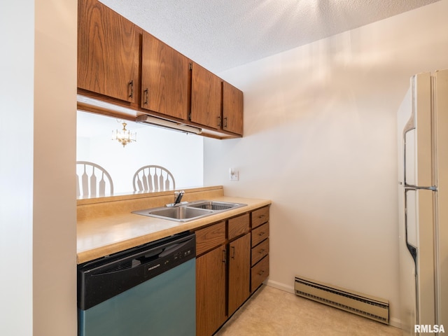 kitchen featuring light countertops, baseboard heating, freestanding refrigerator, a sink, and dishwasher