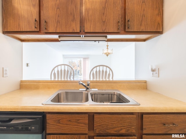 kitchen featuring brown cabinets, light countertops, a sink, and dishwasher