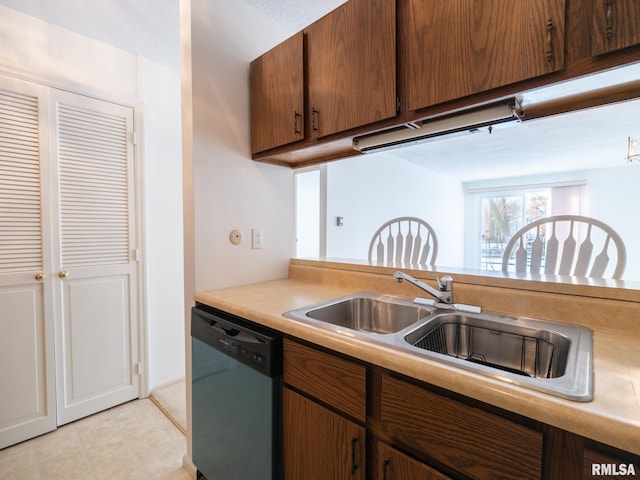 kitchen featuring light countertops, dishwasher, and a sink