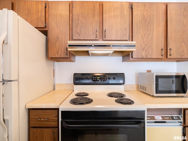 kitchen with under cabinet range hood, range with electric stovetop, light countertops, freestanding refrigerator, and stainless steel microwave